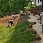 Backyard landscaping and sod installation in progress with stone patio and grading work in Mississauga