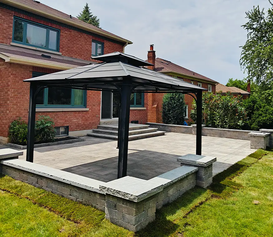 Completed backyard interlock area with gazebo and clean stone layout