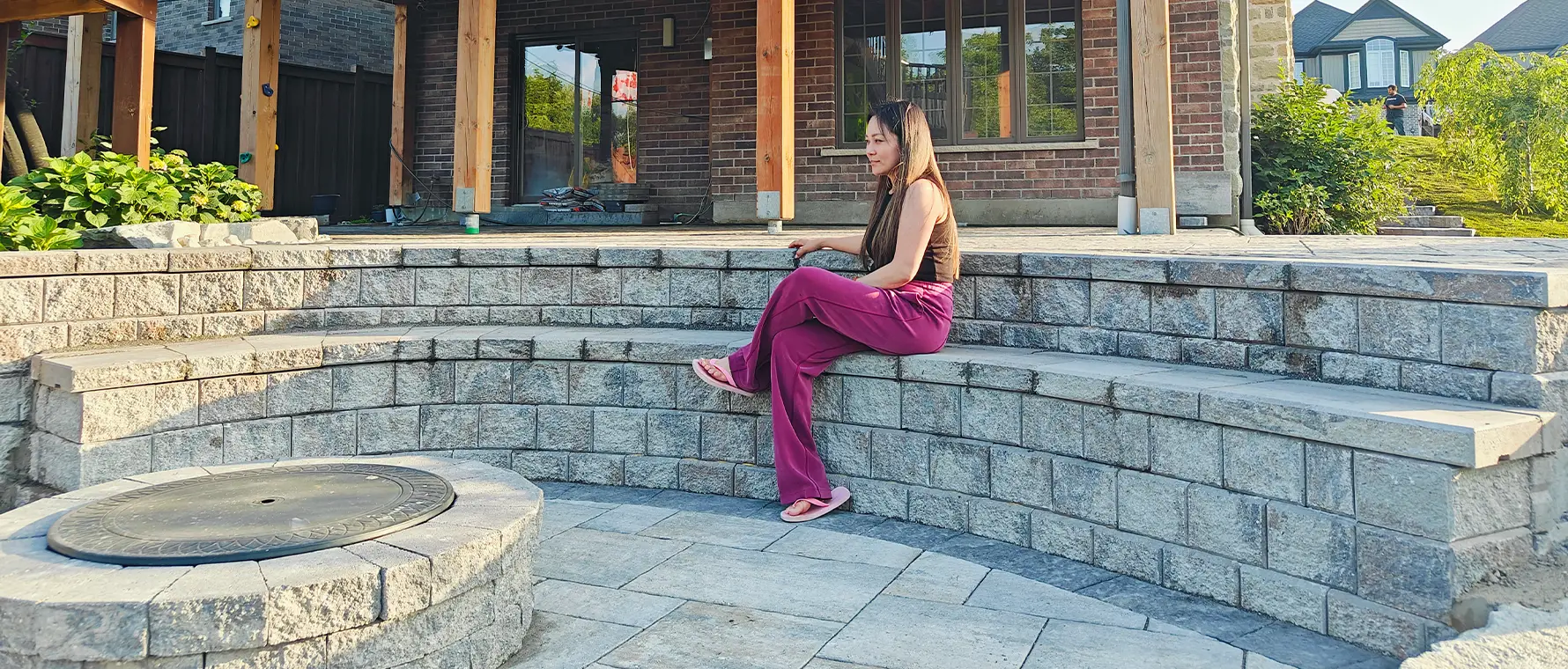 Curved interlock seating wall and patio installation in Kitchener Ontario beneath covered deck