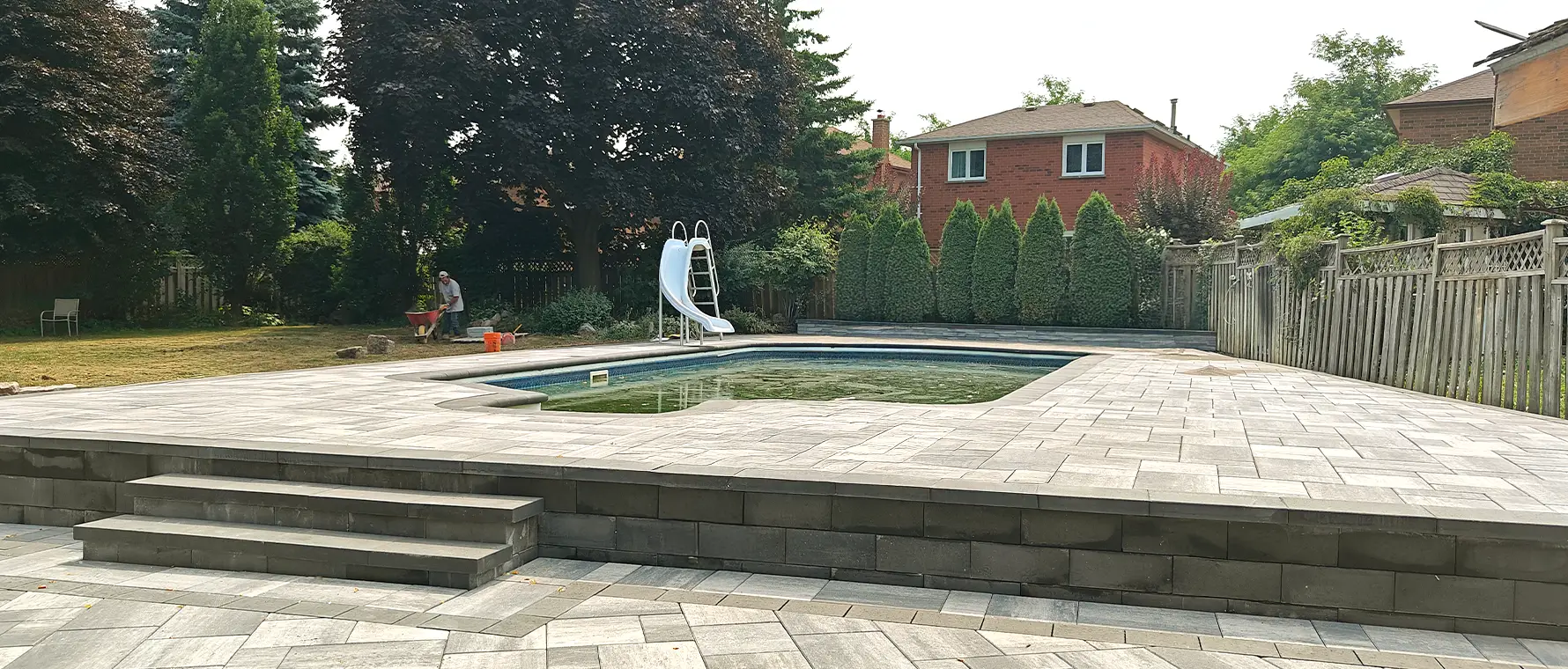 Custom interlock pool deck installation in Brampton Ontario with raised platform and steps