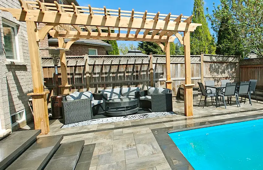 Custom pergola and deck built by professional landscape and hardscape contractors in a backyard setting