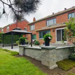 Finished backyard hardscape with raised interlock area and gazebo structure