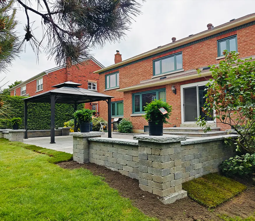Finished backyard hardscape with raised interlock area and gazebo structure