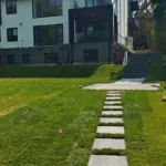 Finished backyard landscape with sod installation, concrete stepping stone pathway, and elevated stone stairs in Mississauga