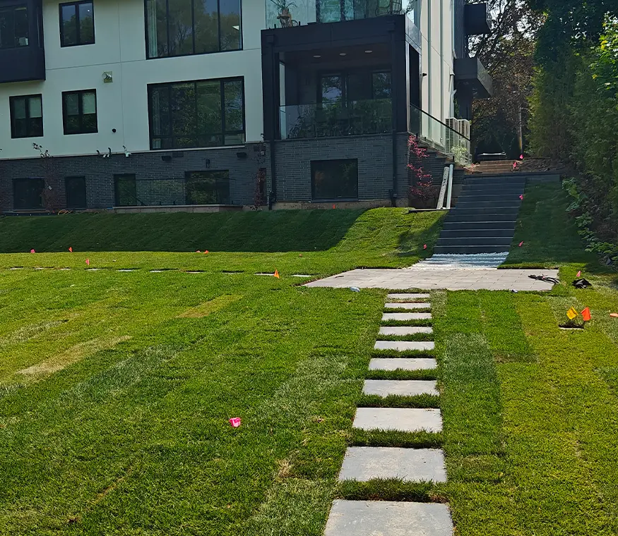 Finished backyard landscape with sod installation, concrete stepping stone pathway, and elevated stone stairs in Mississauga