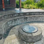 Finished interlock patio in Kitchener Ontario with deck access and stone border