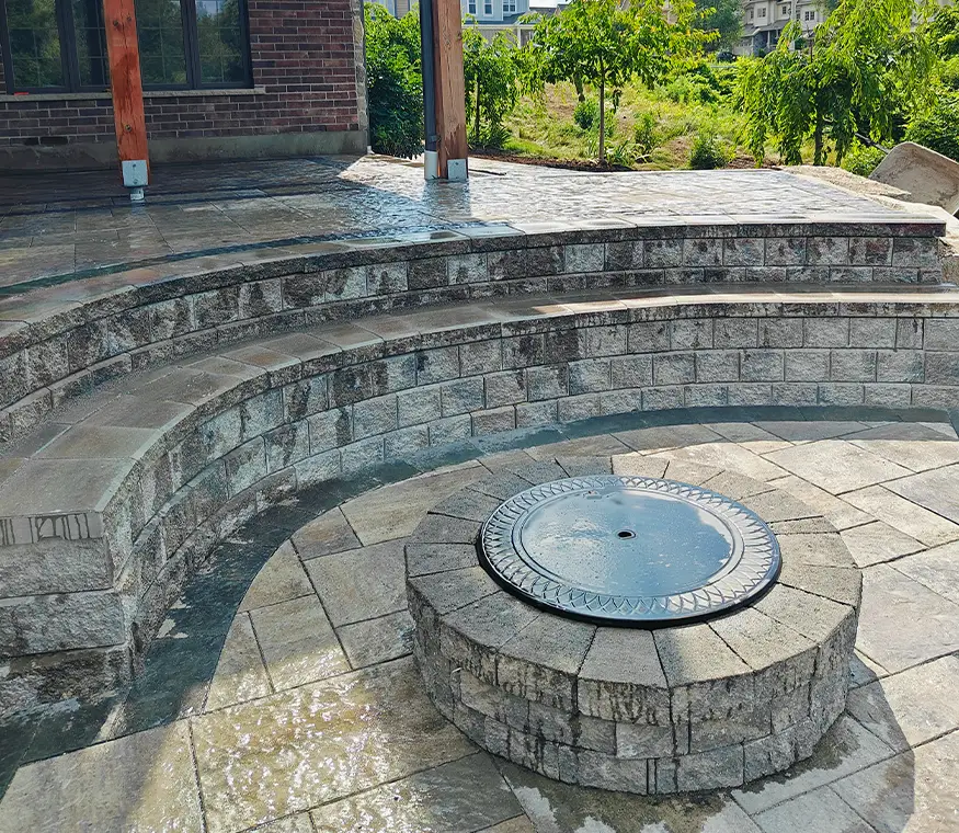 Finished interlock patio in Kitchener Ontario with deck access and stone border