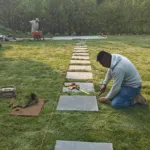 Installation of stone stepping path across freshly laid sod lawn in Mississauga backyard landscape