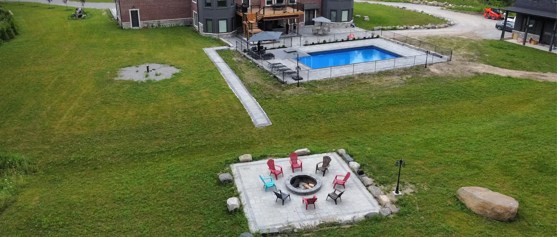 Interlock patio beneath elevated deck with wood stairs and black railing in Wasaga Beach