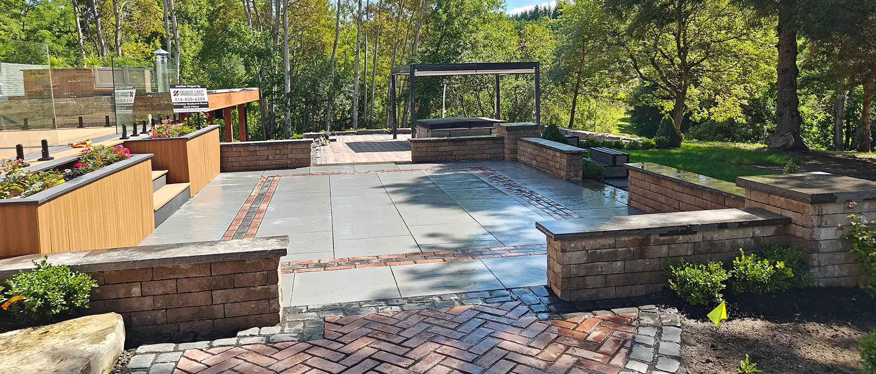 Large-format interlock patio installation in Aurora Ontario with built-in seating walls by professional hardscape contractors