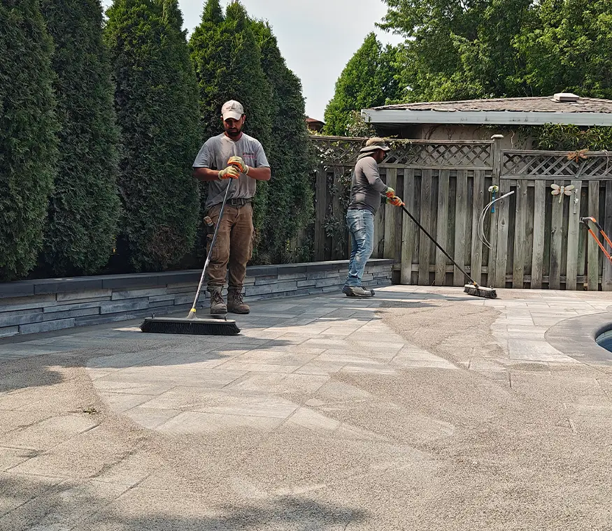 Sand sweeping and final surface preparation on interlock patio in Brampton Ontario