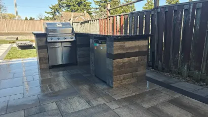 Outdoor BBQ station with stonework by professional landscape contractor