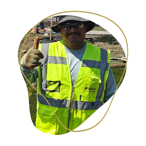 Professional landscaping crew member giving a thumbs up on a completed outdoor construction project