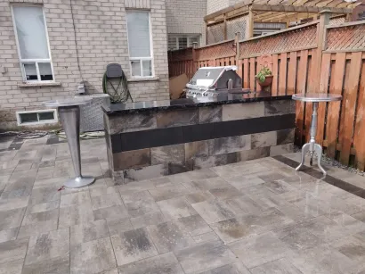 Residential outdoor BBQ setup with stone finish by landscape contractor
