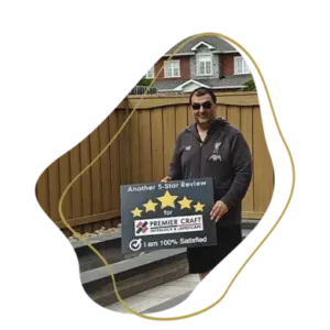Satisfied landscaping customer holding a five-star review sign after completed interlock and patio project